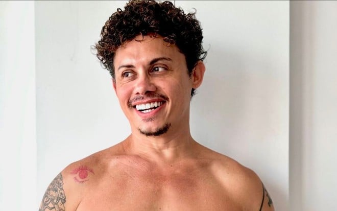 Silvero Pereira está sem camisa e sorri; ele olha para um ponto fixo a direita em foto publicada nas redes sociais