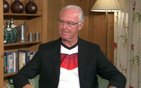 Franz Beckenbauer contorce a boca durante entrevista ao SporTV