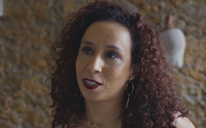Thalita Carauta com sorriso discreto em cena da novela Todas as Flores