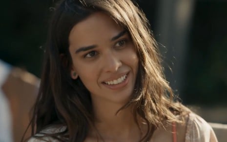 Theresa Fonseca com expressão sorridente em cena como Mariana na novela Renascer