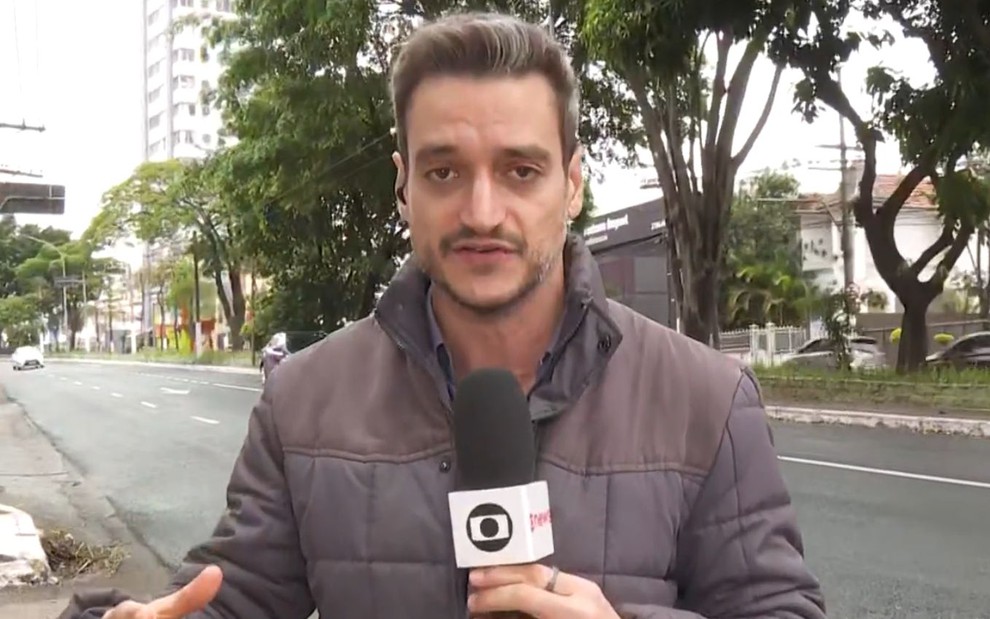 Tiago Scheuer segurando o microfone da Globo