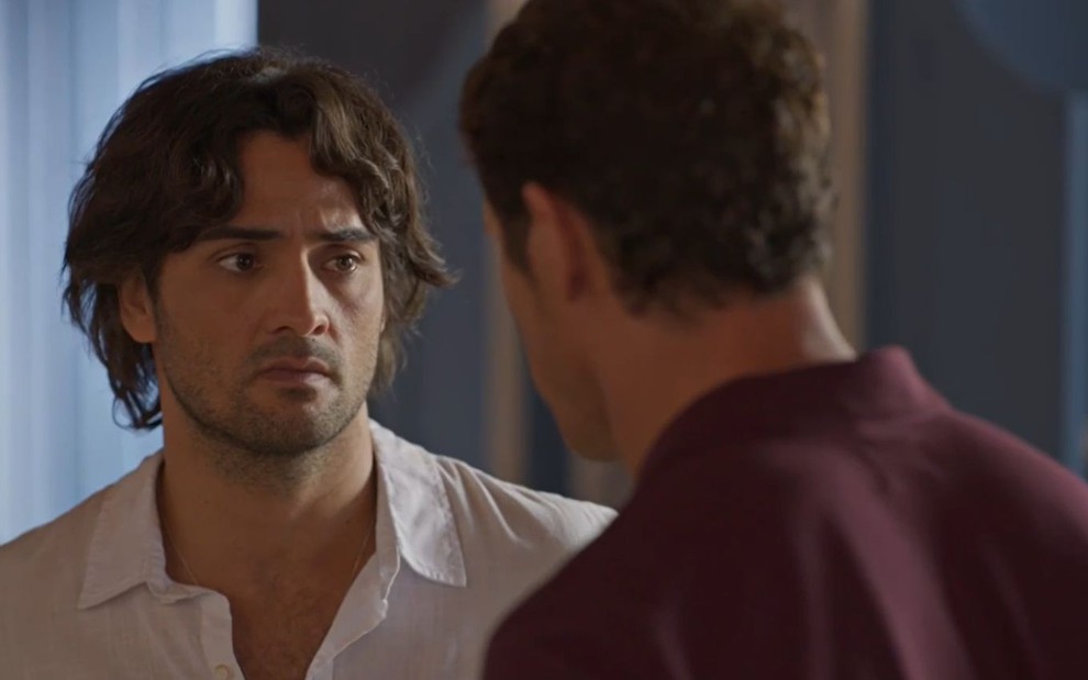 Artur (Túlio Starling) encara Marcelo (José Loreto), que está de costas em cena da novela No Rancho Fundo
