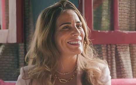 A atriz Gloria Pires está sorrindo em cena da novela Terra e Paixão como a personagem Irene