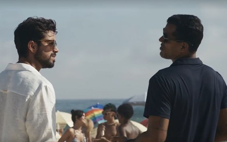 Em cena de Renascer, Rodrigo Simas está conversando com Marcello Melo Jr; ambos estão de costas, olhando para o outro