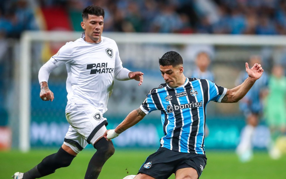 Víctor Cuesta marca Luis Suárez, que faz movimento para chutar a bola em jogo Grêmio x Botafogo no Brasileirão