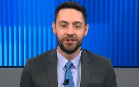 Vitor Brown usa terno cinza e gravata azul no programa Linha de Frente