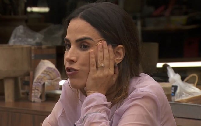 Wanessa Camargo está com uma mão na bochecha e come na cozinha do BBB 24