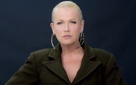 Xuxa Meneghel está com expressão séria e usa um blazer preto