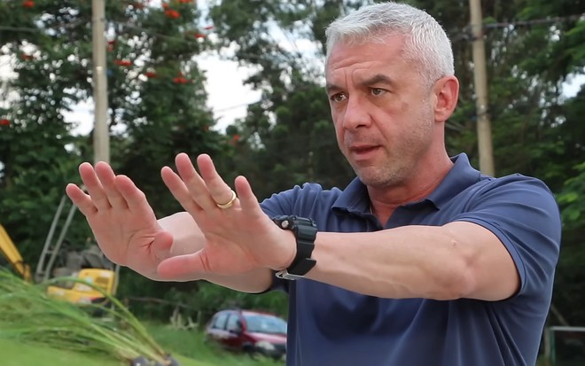 Alexandre Correa com as mãos espalmadas para a frente em vídeo do canal de Ana Hickmann em junho de 2022