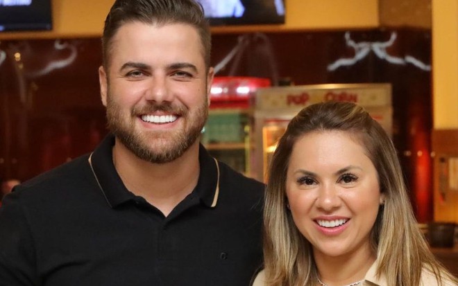Zé Neto e Natália Toscano posam sorridentes na entrada de um cinema
