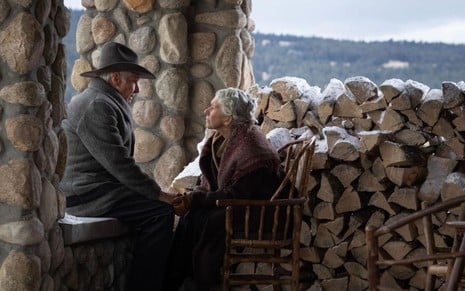 Jacob (Harrison Ford) e Cara (Helen Mirren)  em frente a várias toras de madeira cortadas para virar lenha em 1923