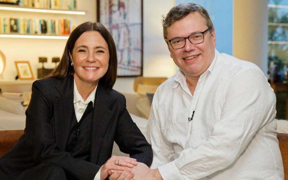 Adriana Esteves e João Emanuel Carneiro em entrevista ao Fantástico para divulgar a novela Mania de Você; ela veste paletó preto e ele, camisa branca