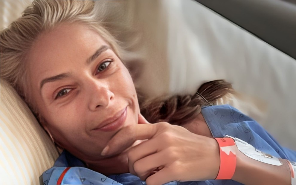 Adriane Galisteu deitada em cama de hospital