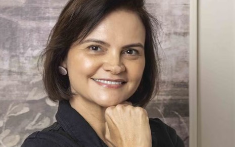 Alessandra Poggi posando sorridente, com a mão ao queixo