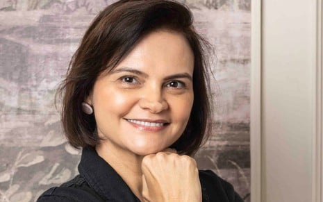 Mulher branca, de cabelos escuros na altura do pescoço, usando camisa preta.