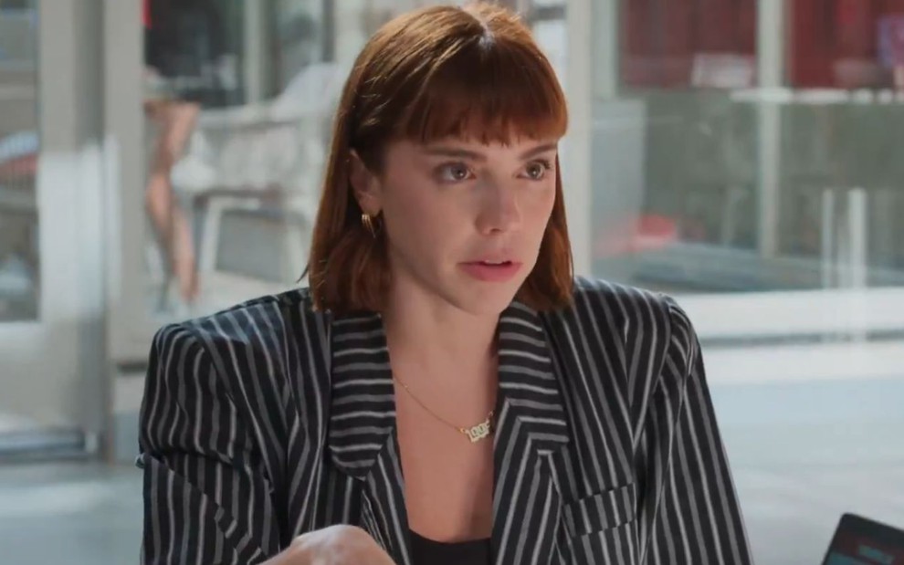 Solange (Alice Wegmann) na Tomorrow, usando um blazer preto com listas brancas, e feição séria