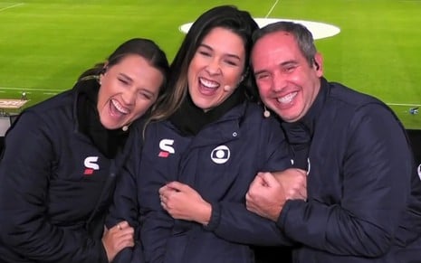 Ana Thaís Matos, Renata Silveira e Caio Ribeiro na cabine de locução do Morumbi, abraçados e sorridentes