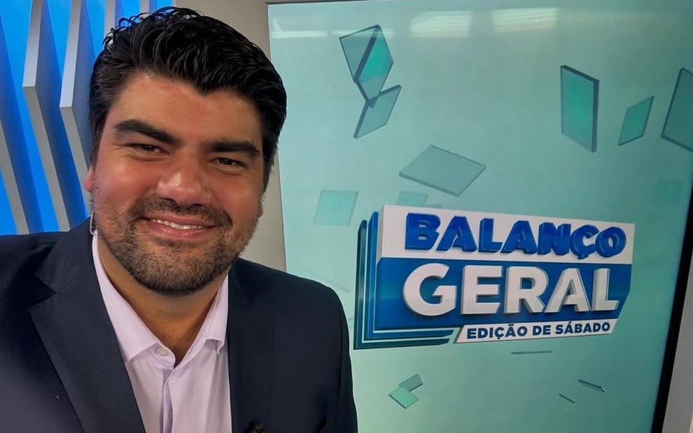 O jornalista André Azeredo posa no cenário do Balanço Geral