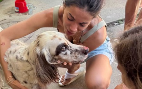 Anitta abraçando seu cachorro, Charlie, e chorando