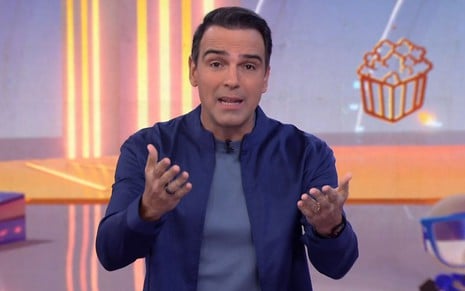 Foto de Tadeu Schmidt na apresentação do BBB 25; ele veste camiseta azul e casaco azul