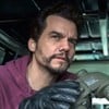 Wagner Moura usa um moletom roxo e segura binóculos em cena de Ladrões de Drogas; ao lado dele está o ator Brian Tyree Henry