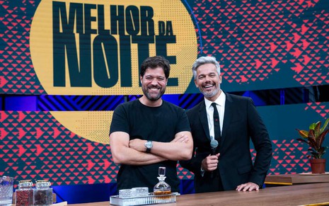 O diretor Ariel Jacobowitz e o apresentador Otaviano Costa no cenário do Melhor da Noite, da Band. Ariel usa camiseta preta e Otaviano, terno e gravata