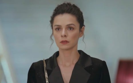 A atriz Özge Özpirinçci com expressão séria em cena de Força de Mulher