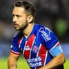 Everton Ribeiro, do Bahia, veste uniforme listrado em azul, vermelho e branco durante partida