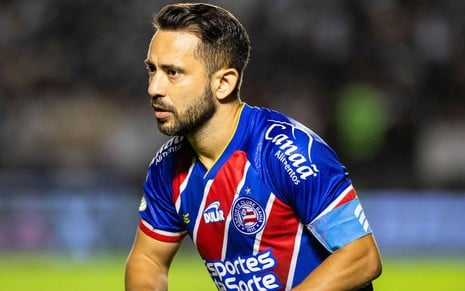 Everton Ribeiro, do Bahia, veste uniforme listrado em azul, vermelho e branco durante partida