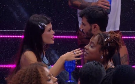 Vitória Strada e Mateus Pires estão no meio da pista de dança; ela está com as mãos apontadas para ele enquanto fala; o brother a encara, sério