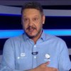 Bruno Laurence está em pé em frente a telão com o logo do JR Esporte