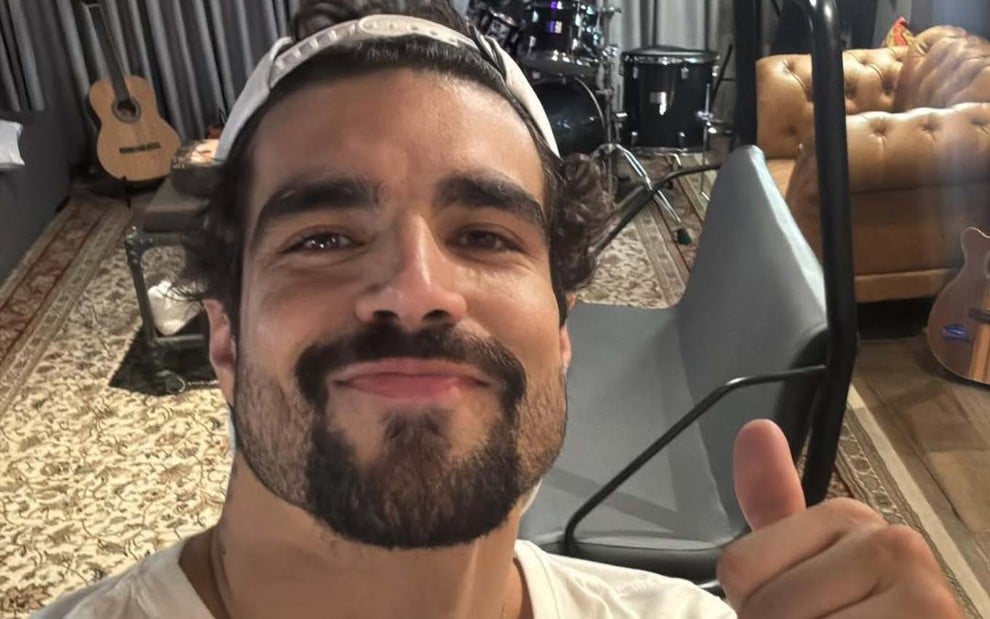 O ator Caio Castro sorrindo de boca fechada, em sua casa, em foto publicada no Instagram