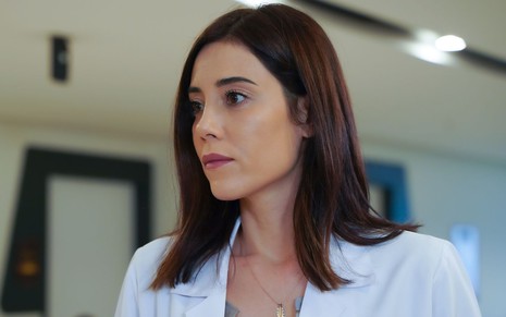 Cansu Dere com expressão séria em cena da novela Iludida