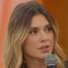 Carolina Dieckmann no sofá do Encontro, com o microfone na mão, usando blazer marrom