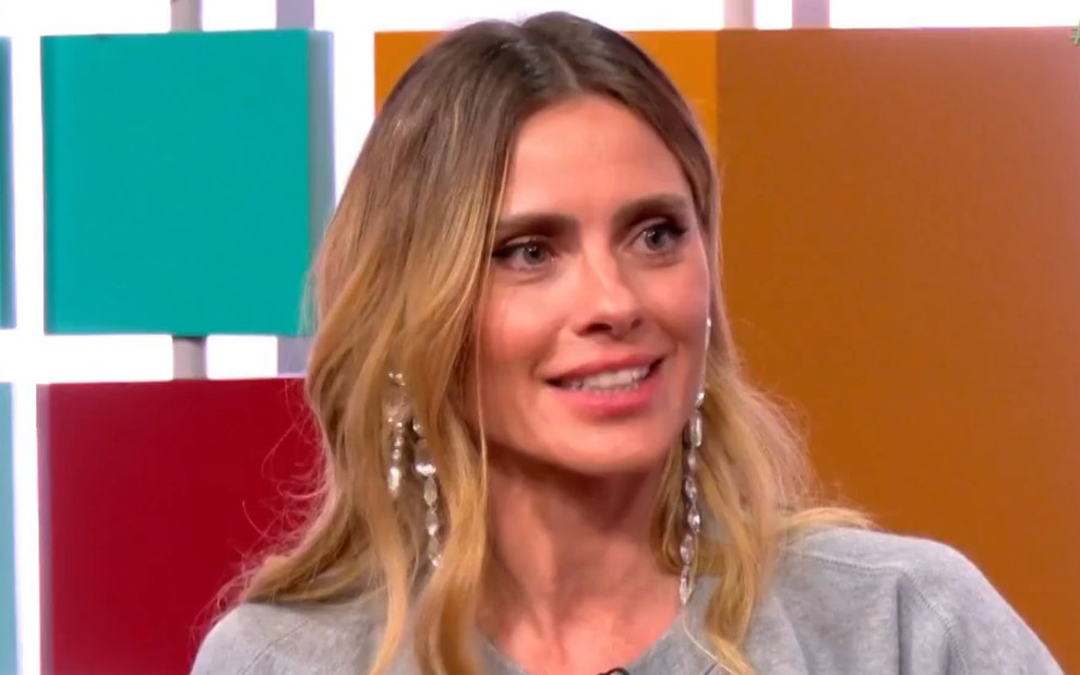 Carolina Dieckmann sentada no cenário colorido do Papo de Segunda