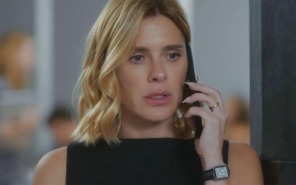 Carolina Dieckmann está com um telefone na orelha em cena da novela Vai na Fé