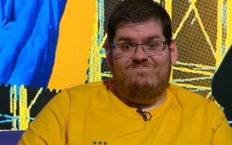 homem branco veste amarelo e faz careta