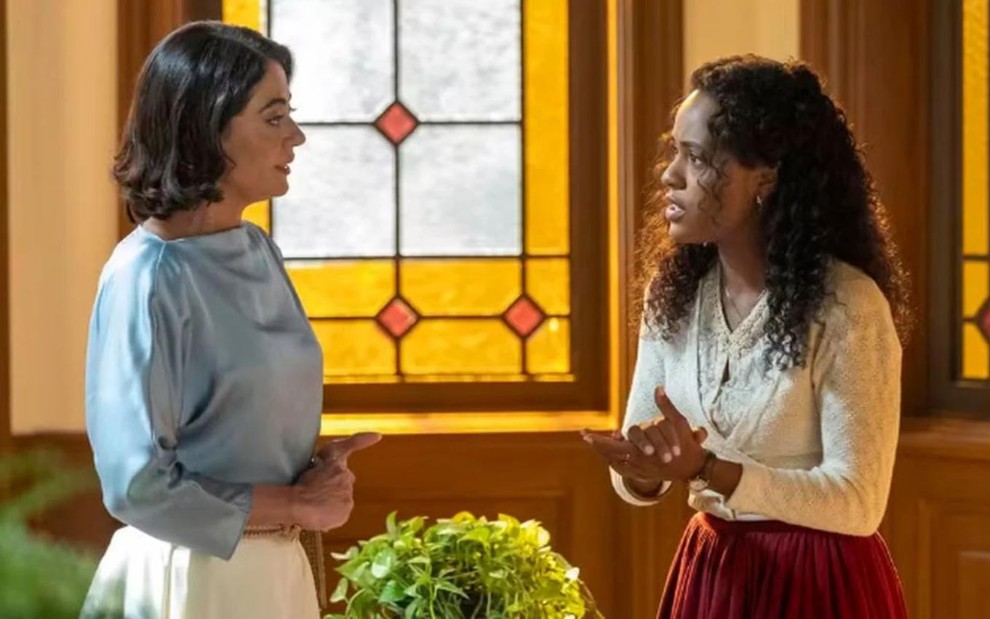 As atrizes Carol Castro e Duda Santos sérias, frente a frente em cena de Garota do Momento