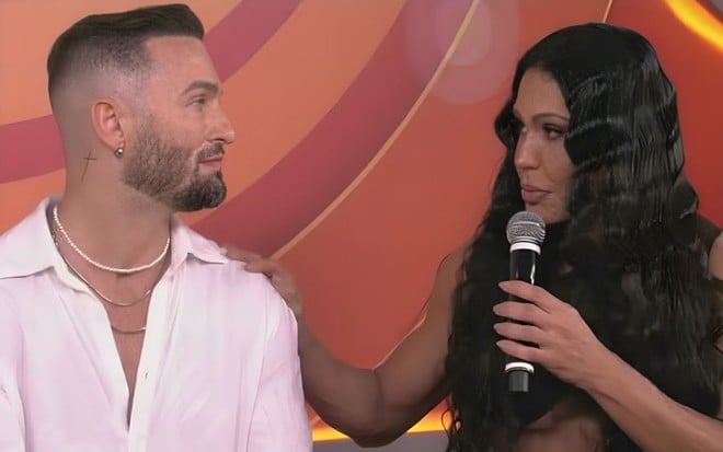Diego Hypolito e Gracyanne Barbosa se entreolhando no Prêmio Gshow BBB 25, ela coloca a mão no ombro dele e segura um microfone