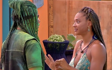 Diogo e Aline se olham no BBB 25; ator está coberto de pó verde, e policial o encara de frente