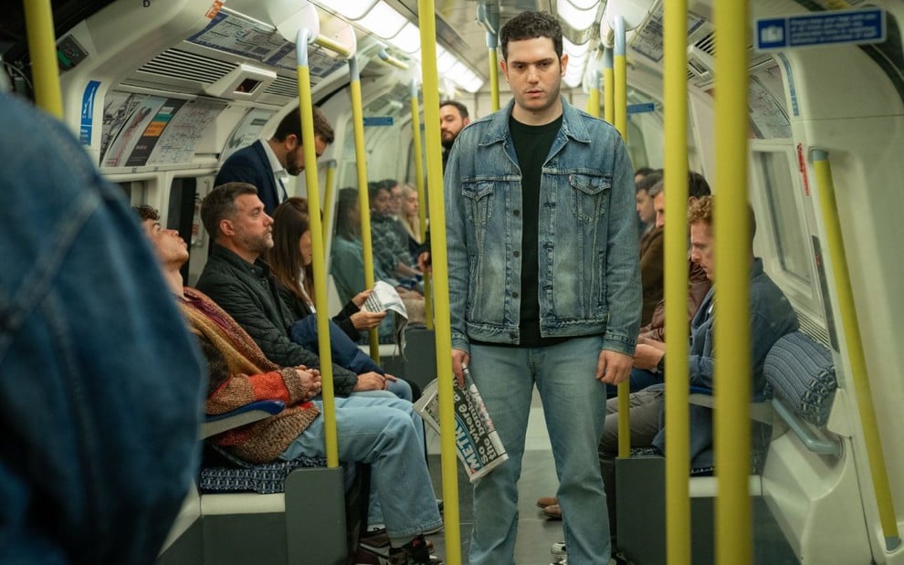 Caracterizado como Jean Charles de Menezes, Edison Alcaide tem expressão séria em metrô de Londres