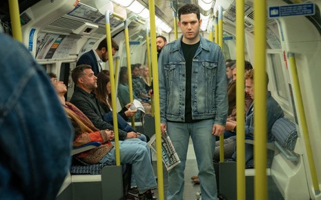 Caracterizado como Jean Charles de Menezes, Edison Alcaide tem expressão séria em metrô de Londres
