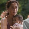 A atriz Camila Pitanga com um bebê no colo, olhando para o ator Tony Ramos em cena de Dona de Mim