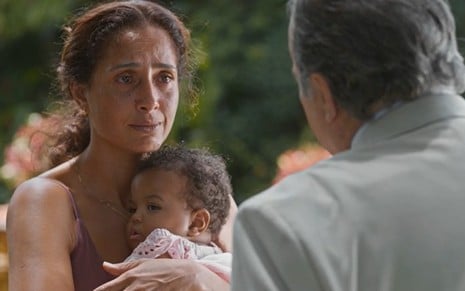 A atriz Camila Pitanga com um bebê no colo, olhando para o ator Tony Ramos em cena de Dona de Mim