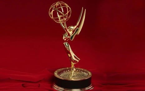 estatueta de ouro do Emmy, em cenário de fundo vermelho
