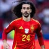 Cucurella, da Espanha, veste uniforme vermelho com detalhes amarelos durante jogo da seleção