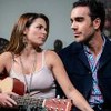 Os atores Alejandra Robles Gil e Marcus Ornellas na novela Eternamente Apaixonados, se olhando, sérios, ela com violão no colo