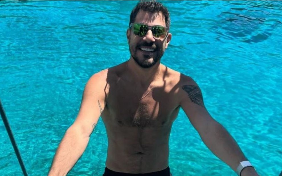 homem curte piscina sem camisa