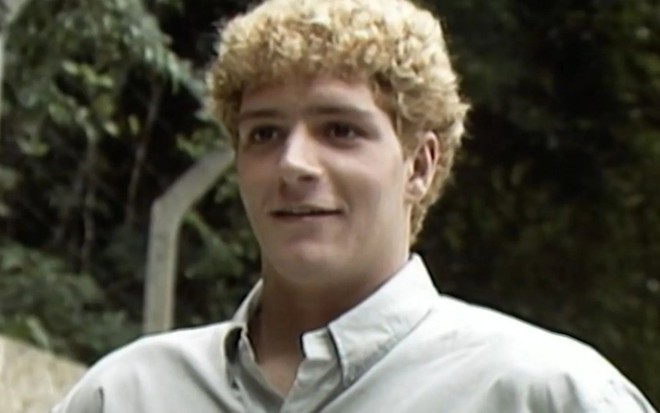 Fabio Villa Verde em cena como Tiago na primeira versão da novela Vale Tudo (1988), com cabelo loiro cacheado, expressão de contemplação