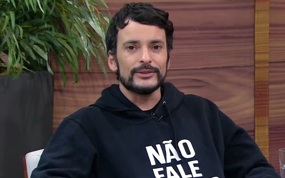 Fefito está com expressão séria e usa um moletom preto